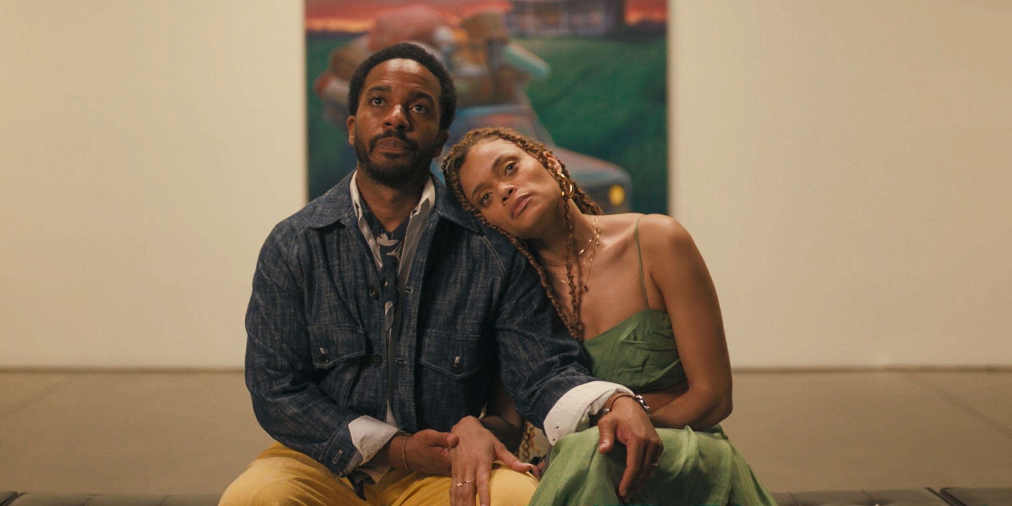 Andre Holland and Andra Day lean on each other while examining a painting in Exhibiting Forgiveness