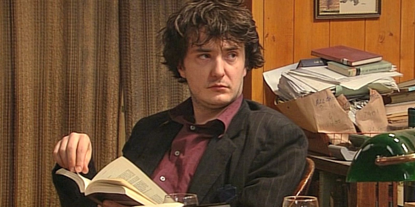 Bernard lendo um livro em Black Books