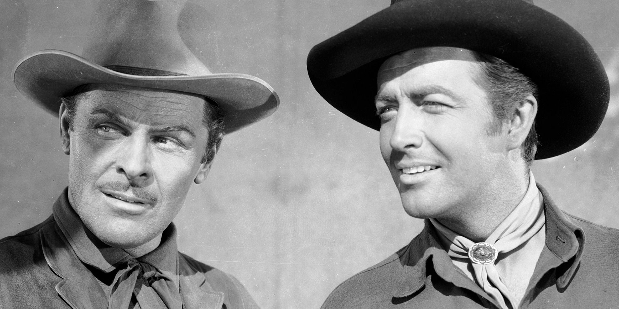 Brian Donlevy and Robert Taylor looking off to the distance in Billy the Kid (1941)