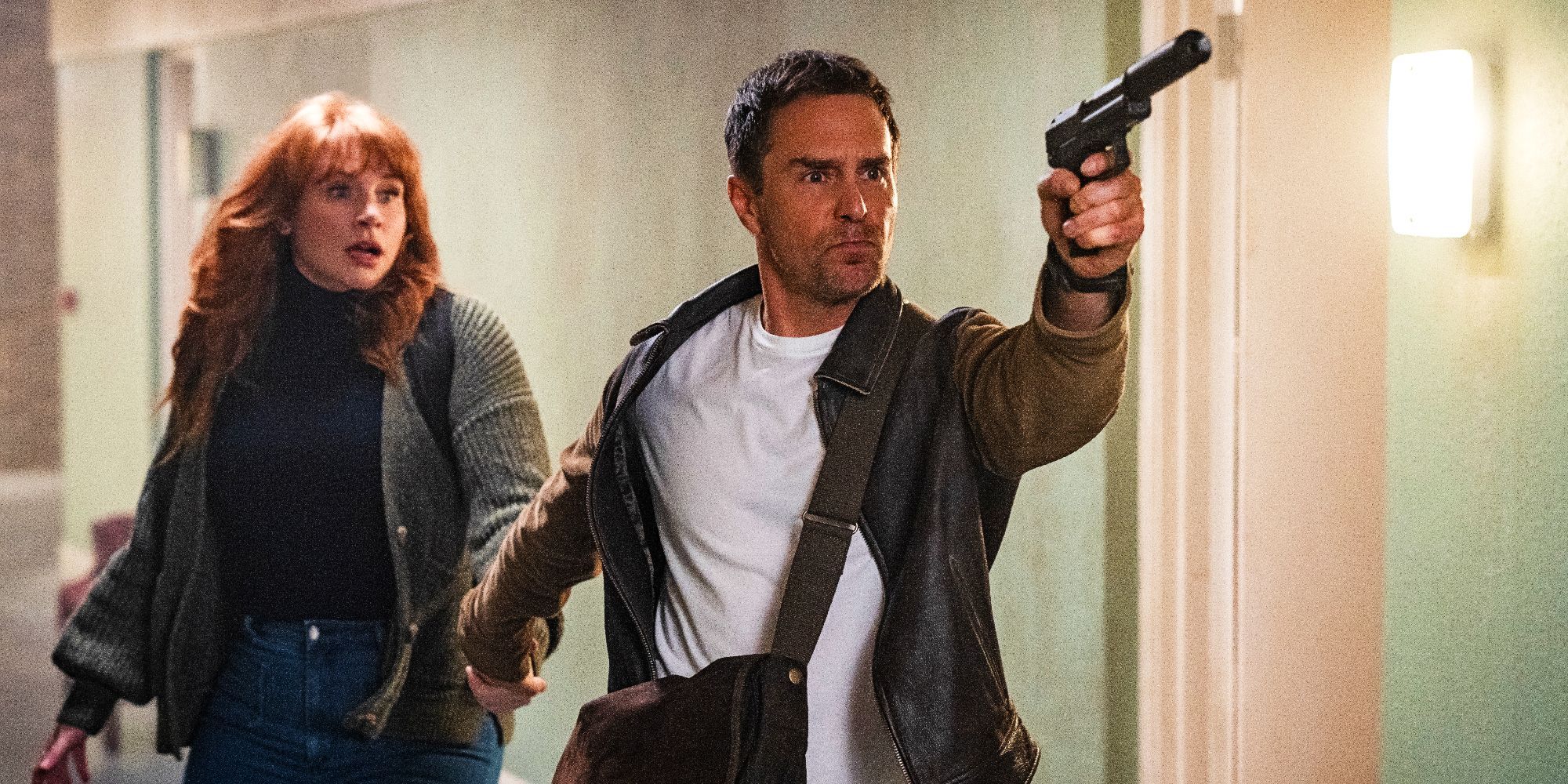 Bryce Dallas Howard as Elly Conway Looking Shocked While Sam Rockwell As Aidan Points A Gun Of Camera In Argylle