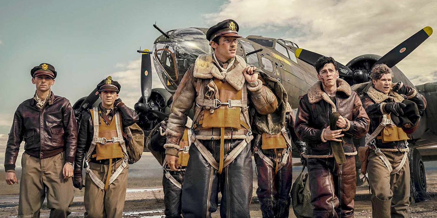 Callum Turner as John Bucky Egann Masters in front a plane with other characters in Masters of the Air