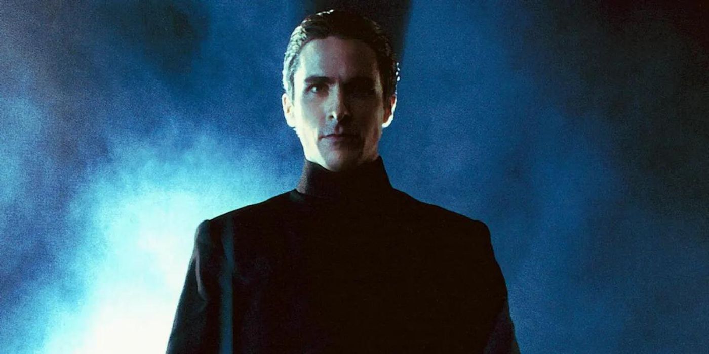 The clergyman John Preston (Christian Bale) stands dramatically in a smoky alley just before a fight scene in Equilibrium
