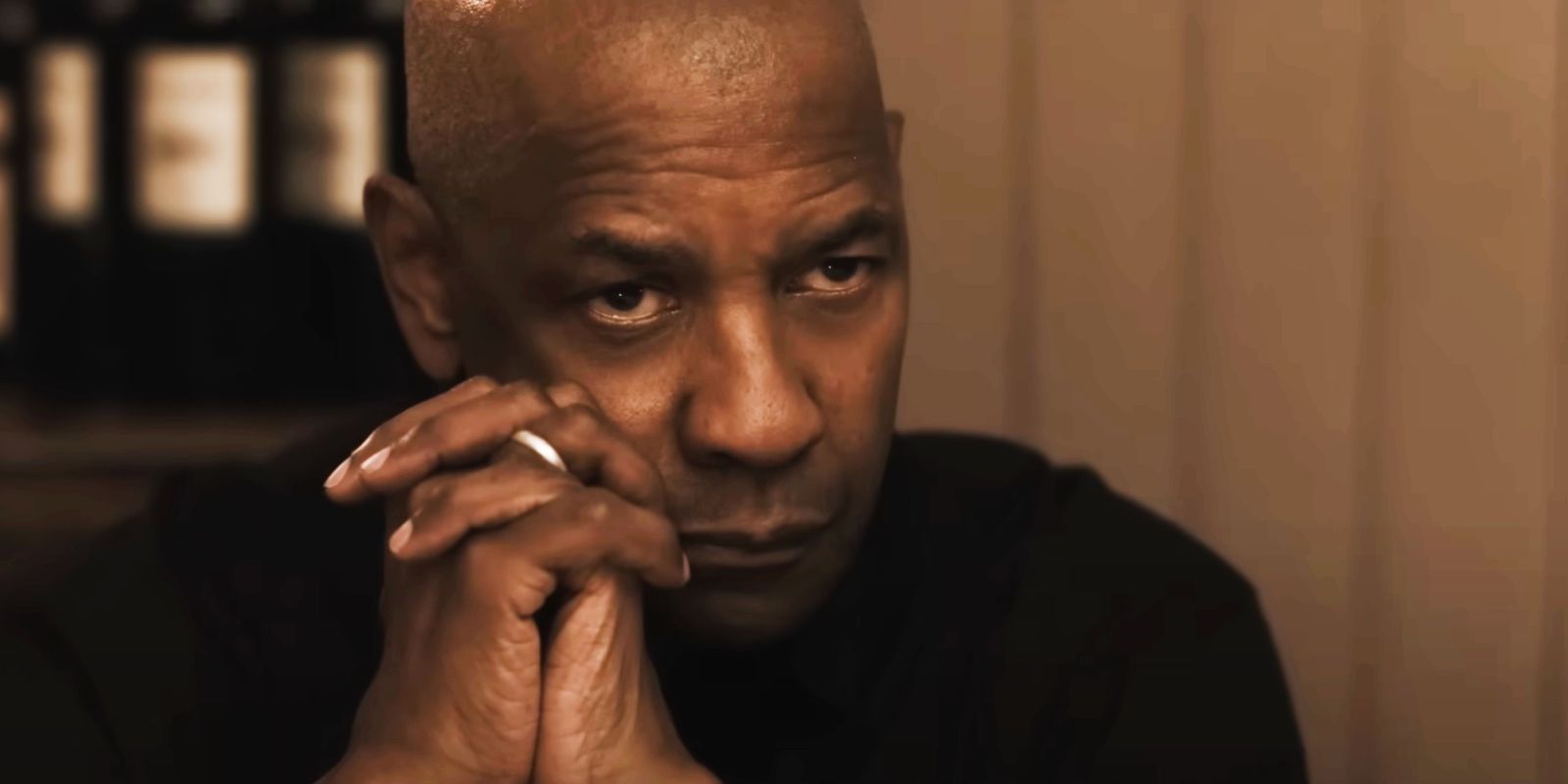 Denzel Washington's Robert McCall leaning on his clasped hands in Equalizer 3