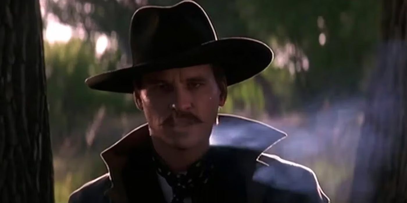 Doc Holliday breaths out the smoke of his cigar.