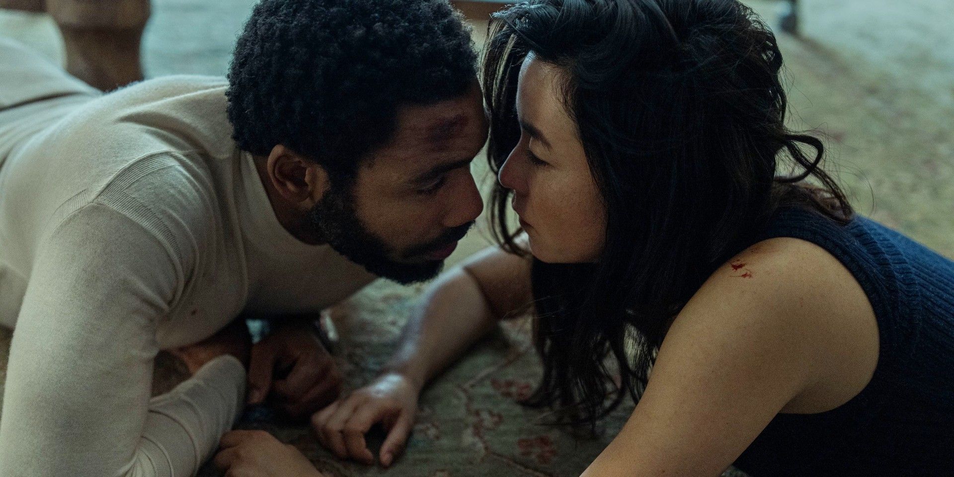 Donald Glover and Maya Erskine face to face while lying on the floor in Mr & Mrs Smith