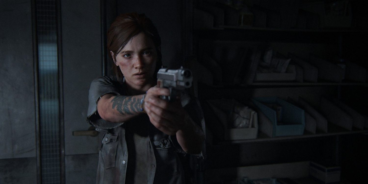 Ellie aponta sua pistola para alguém fora da tela em um quarto escuro em The Last of Us Part II