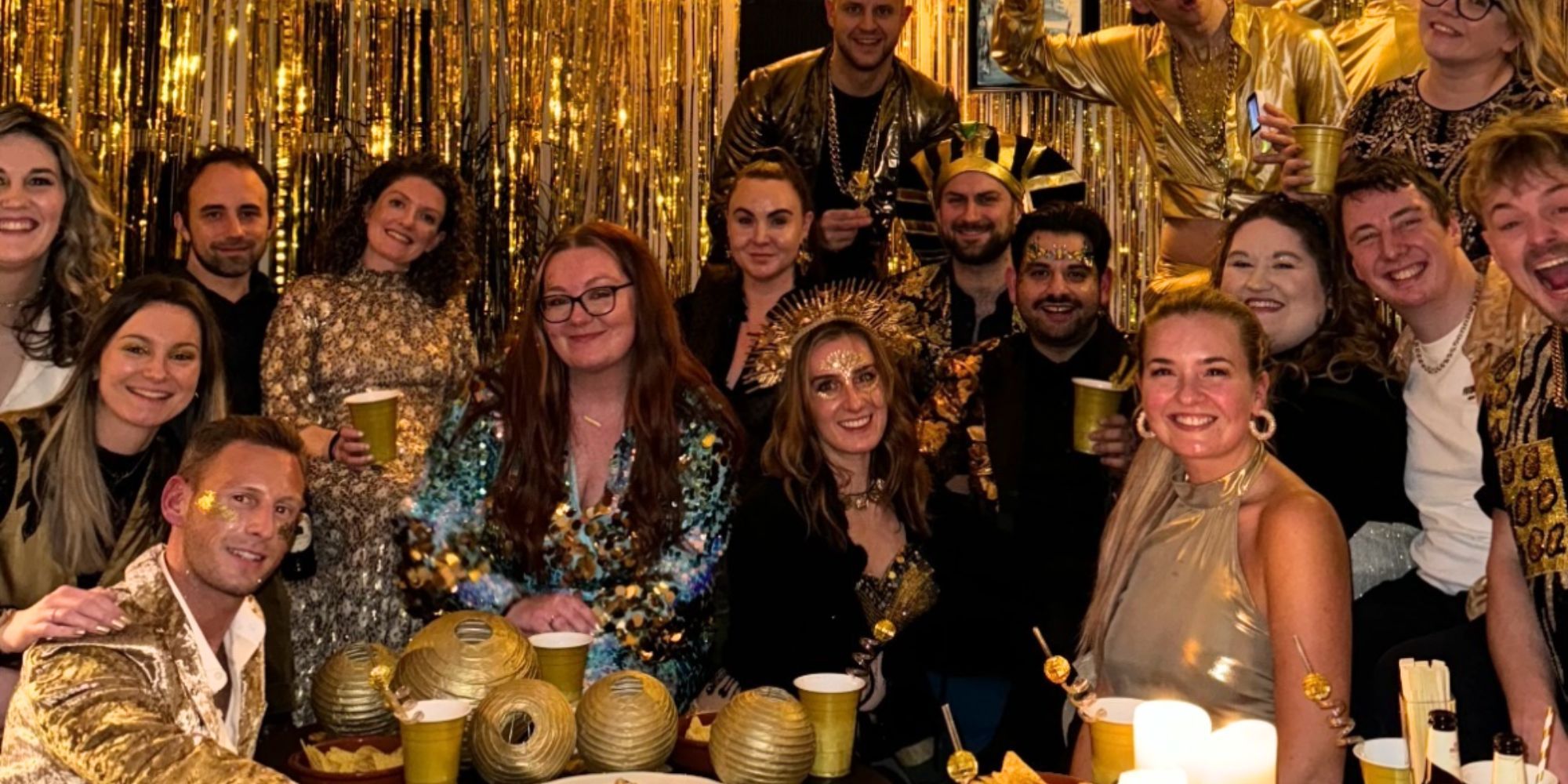 Fraser Olender and Daisy Kelliher from Below Deck posing in gold outfits for New Year's Eve