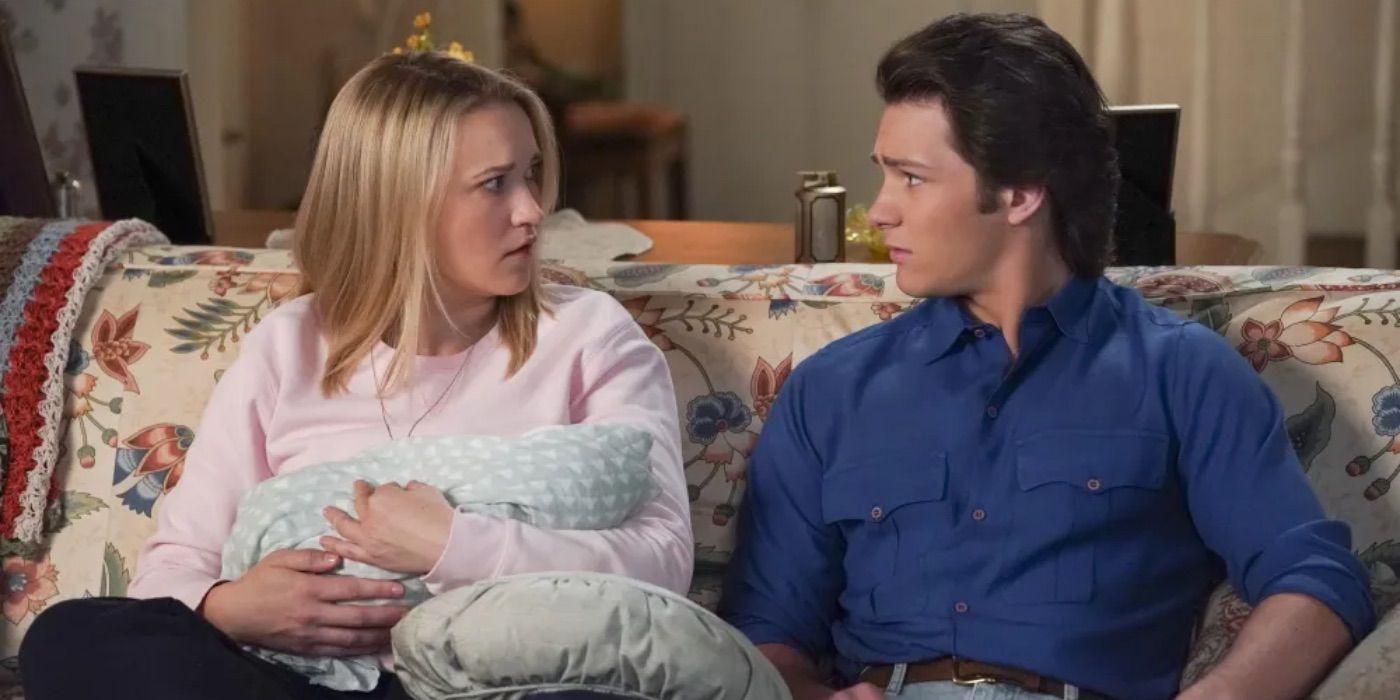 Georgie and Mandy look at each other while sitting on the couch in Young Sheldon