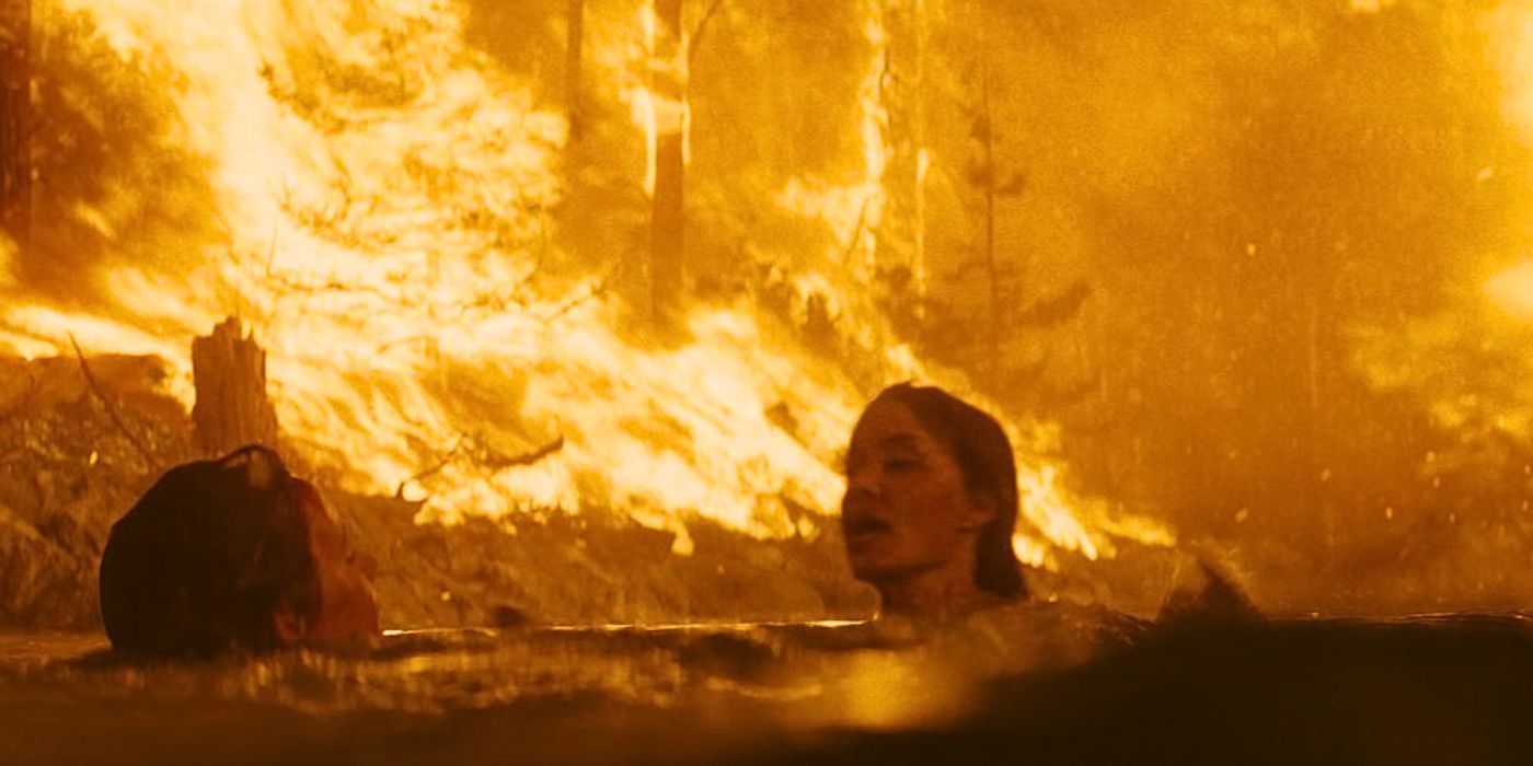 Hannah (Angelina Jolie) and Connor (Finn Little) escape a wildfire in a stream in Those Who Wish Me Dead