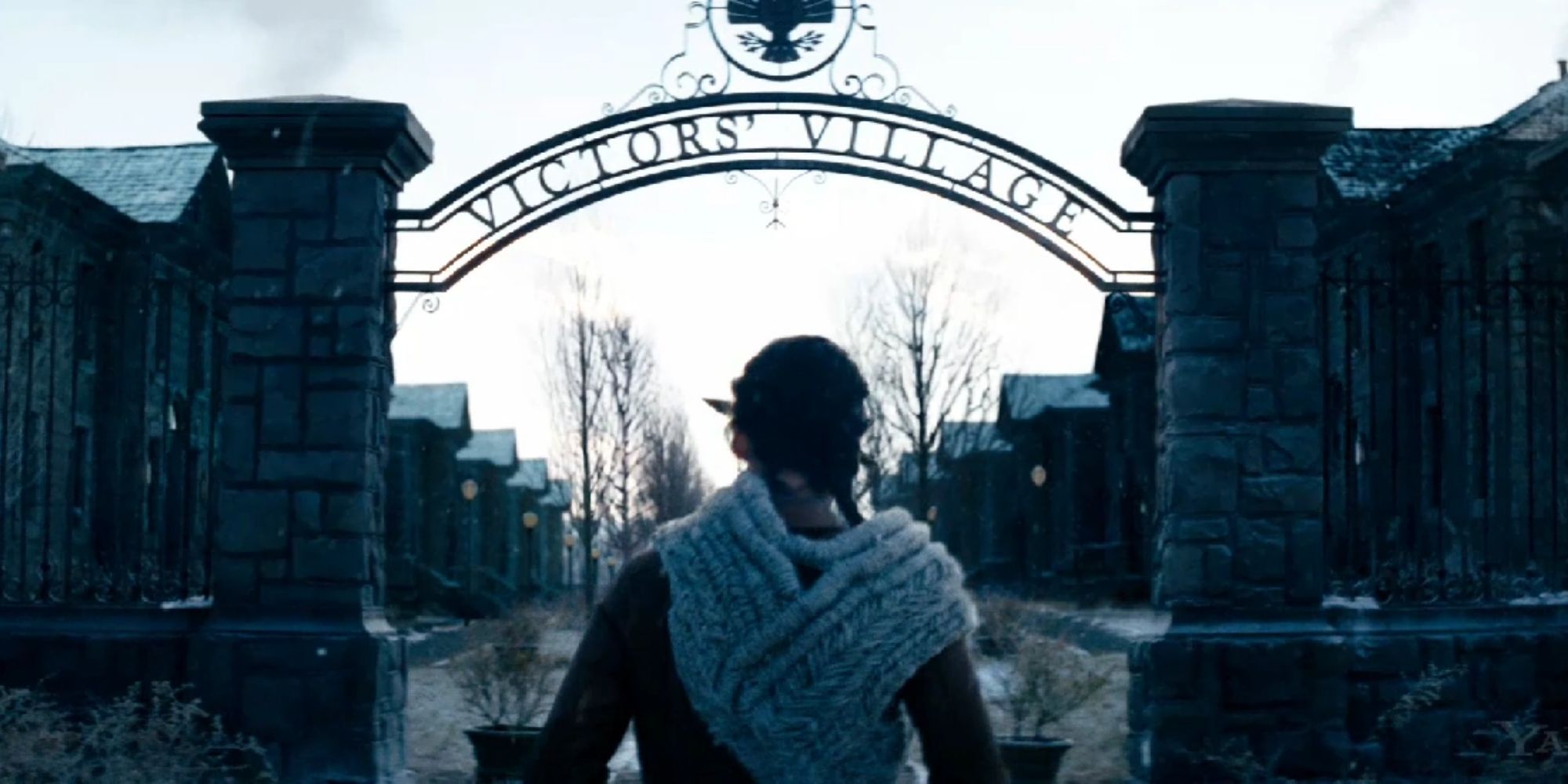 Katniss standing outside of the Gate of Victor's Village in The Hunger Games