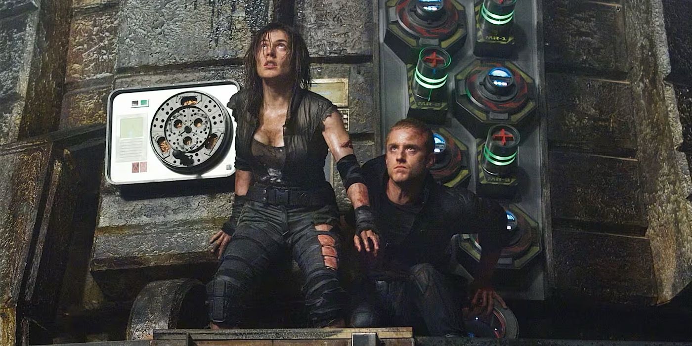 Nadia sits up on her knees while Bower is crouched down on a spaceship in Pandorum.
