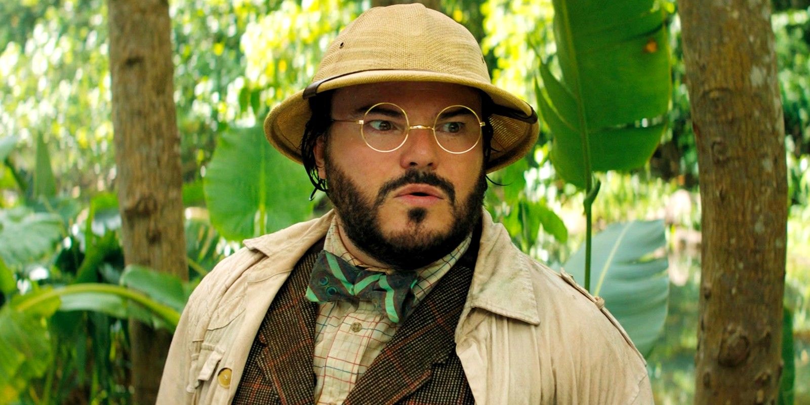 Jack Black in the forest wearing a hat and glasses In Jumanji Next Level