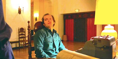 Jack Nicholson's Jack Torrance sits at a desk looking angry in The Shining