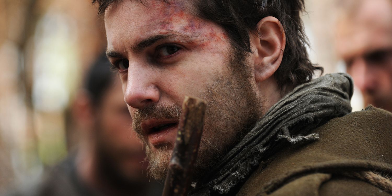 Janusz (Jim Sturgess) with bruises and a stern look on his face in The Way Back