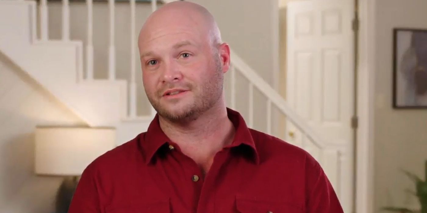 John in 90 Day Fiance wearing red shirt for confessional interview