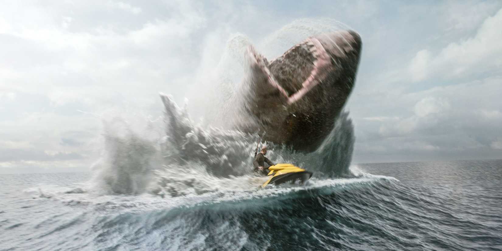 Jonas Taylor rides away from a meg on a jet ski in Meg 2: The Trench