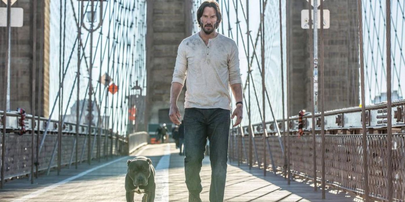 Keanu Reeves as John Wick walks down a bridge with the Unnamed Dog in John Wick: Chapter 2.