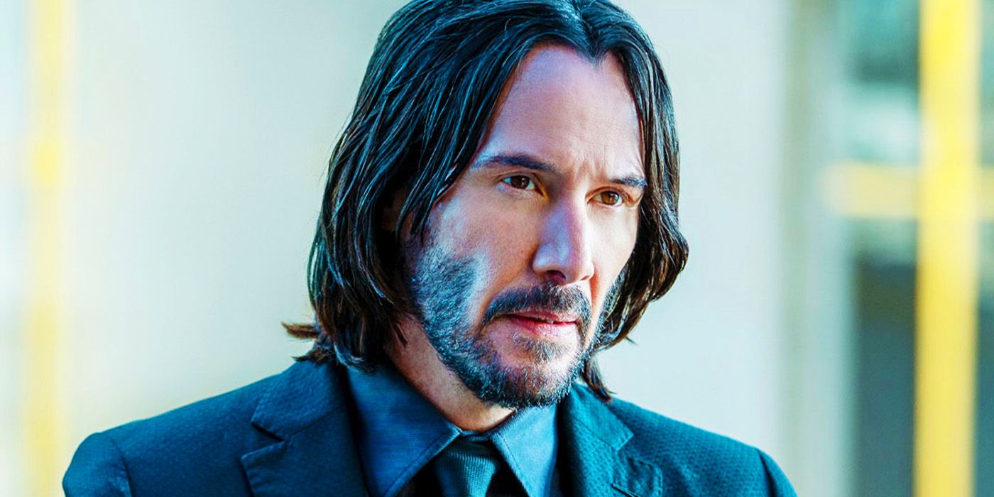 A close-up of John Wick (Keanu Reeves) wearing a suit and  looking pensive in John Wick