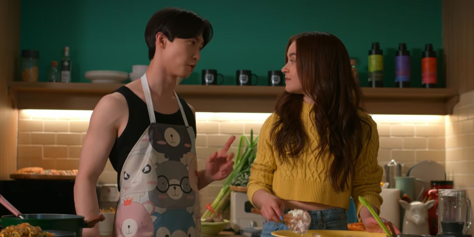 Kitty and Min Ho look at each other while cooking in XO, Kitty.