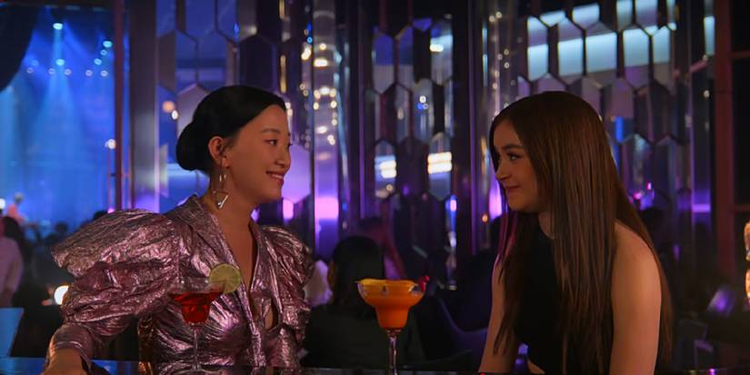 Kitty and Yuri smile at each other while sitting at the bar at Min Ho's party in XO, Kitty