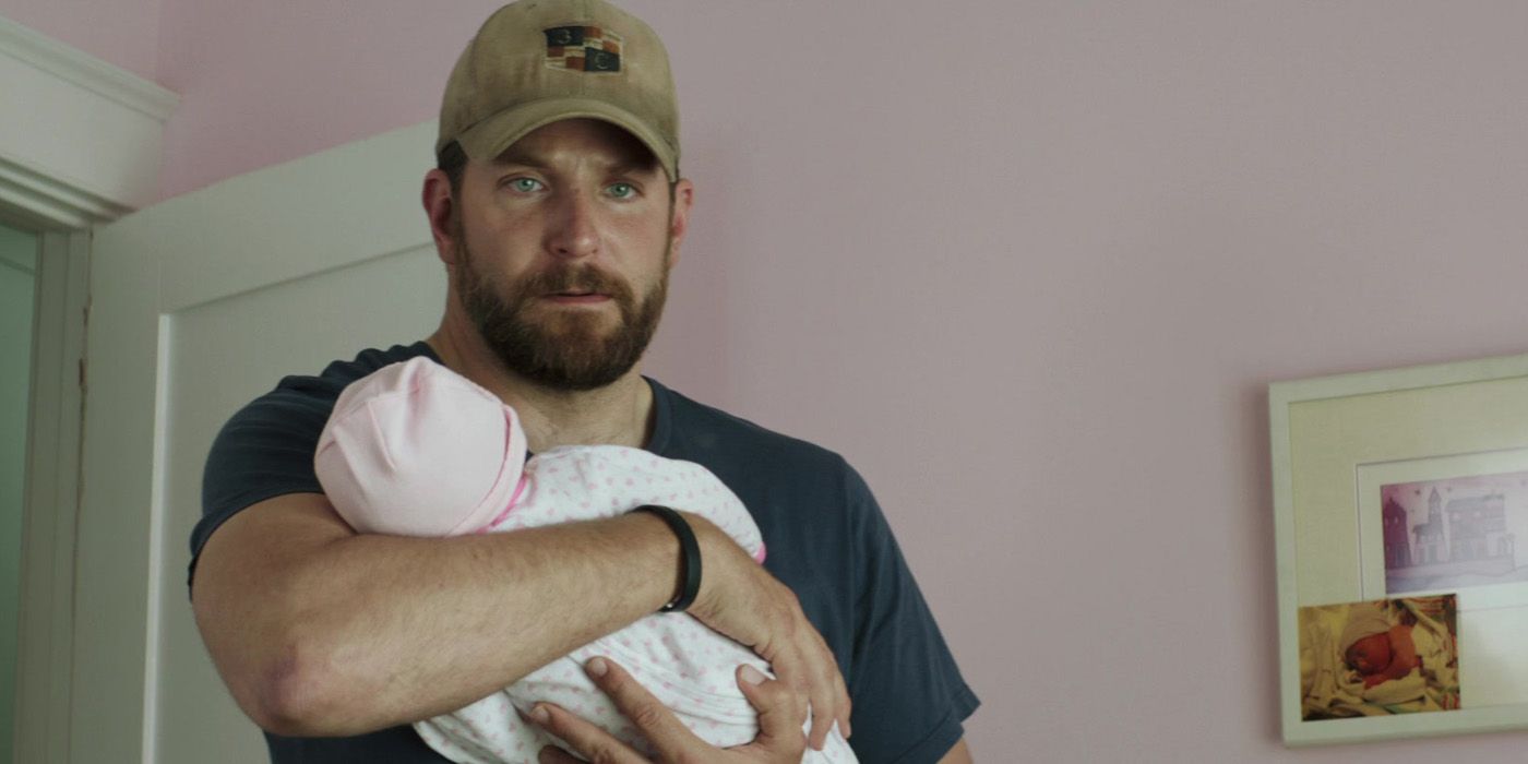 Chris Kyle (Bradley Cooper) sostiene a su bebé en American Sniper