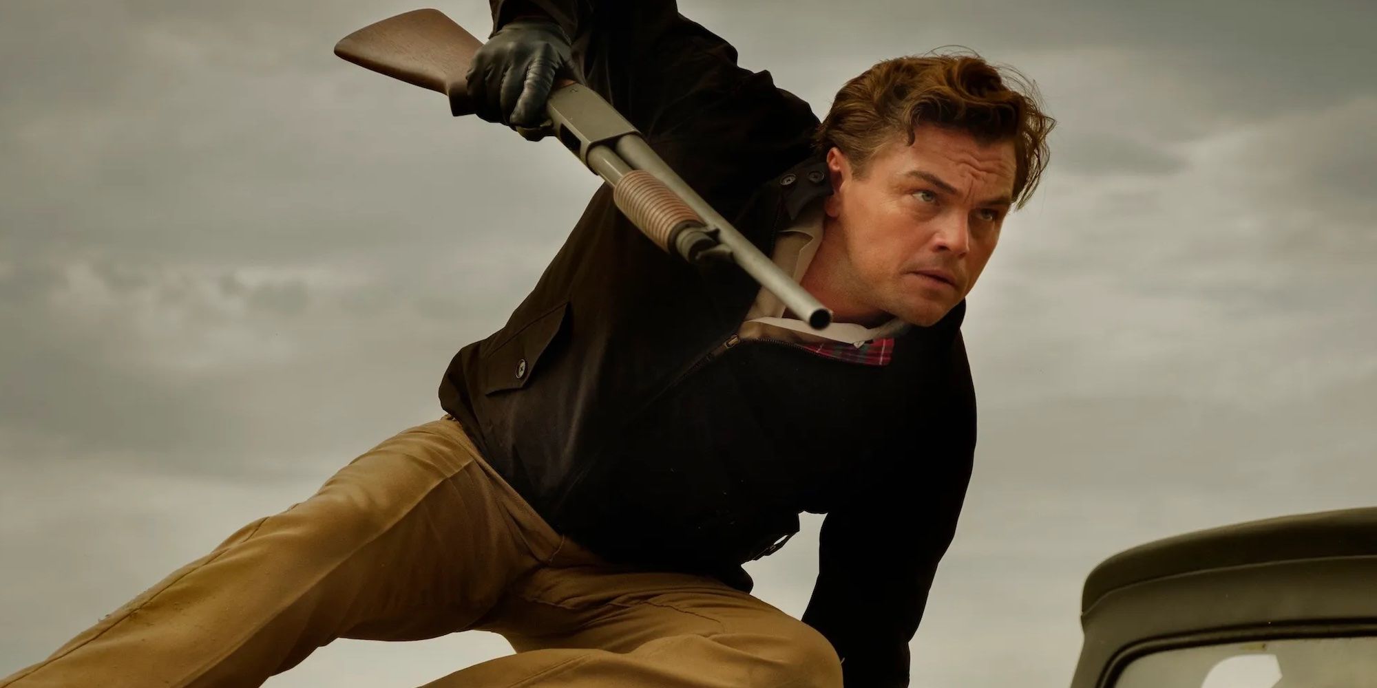 Rick Dalton (Leonardo DiCaprio) jumps over a truck while carrying a shotgun in Once Upon a Time in Hollywood.