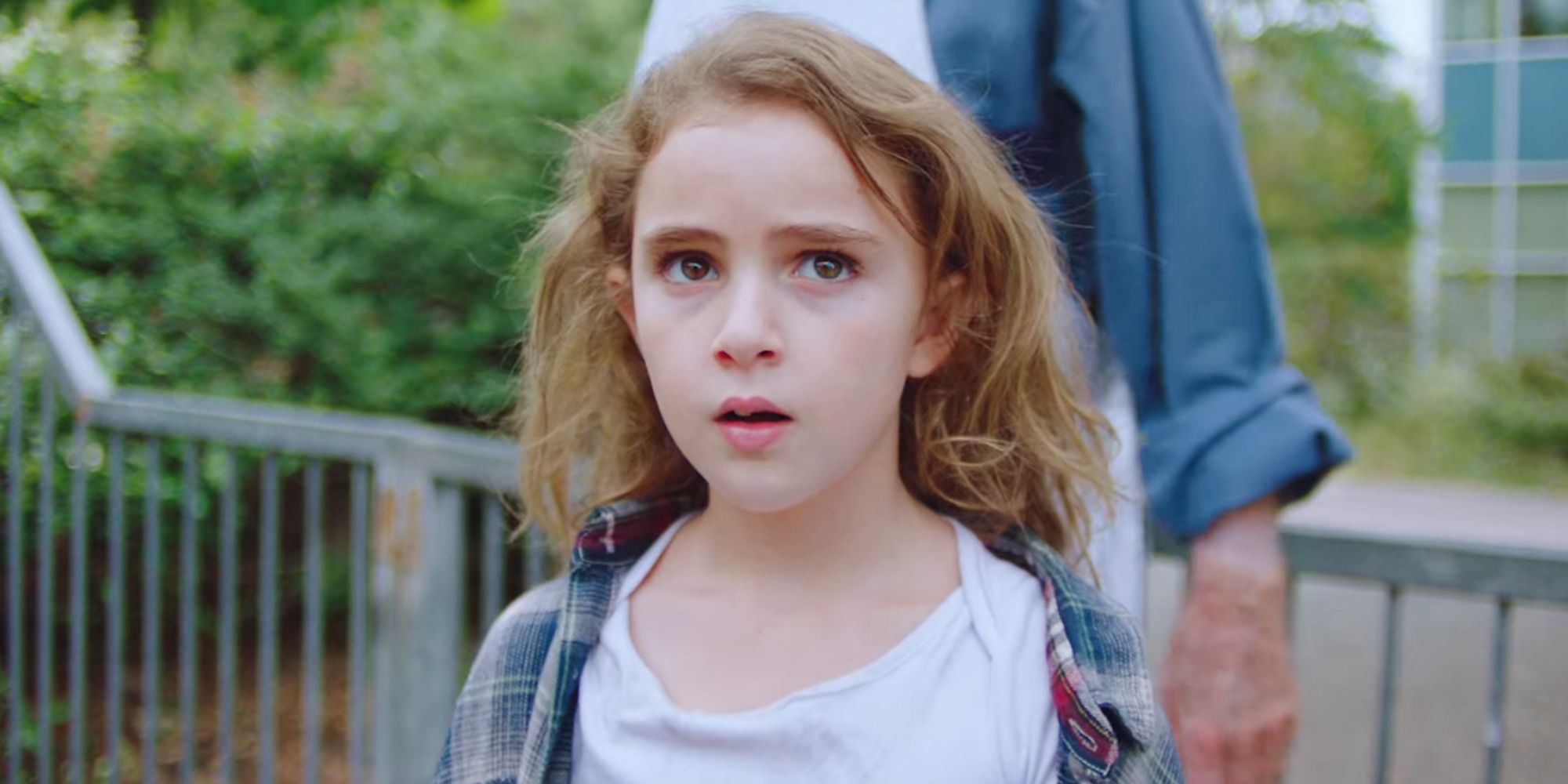 Lexy Kolker as Chloe standing outside in front of a fence wearing a white shirt and oversize flannel in Freaks 2018