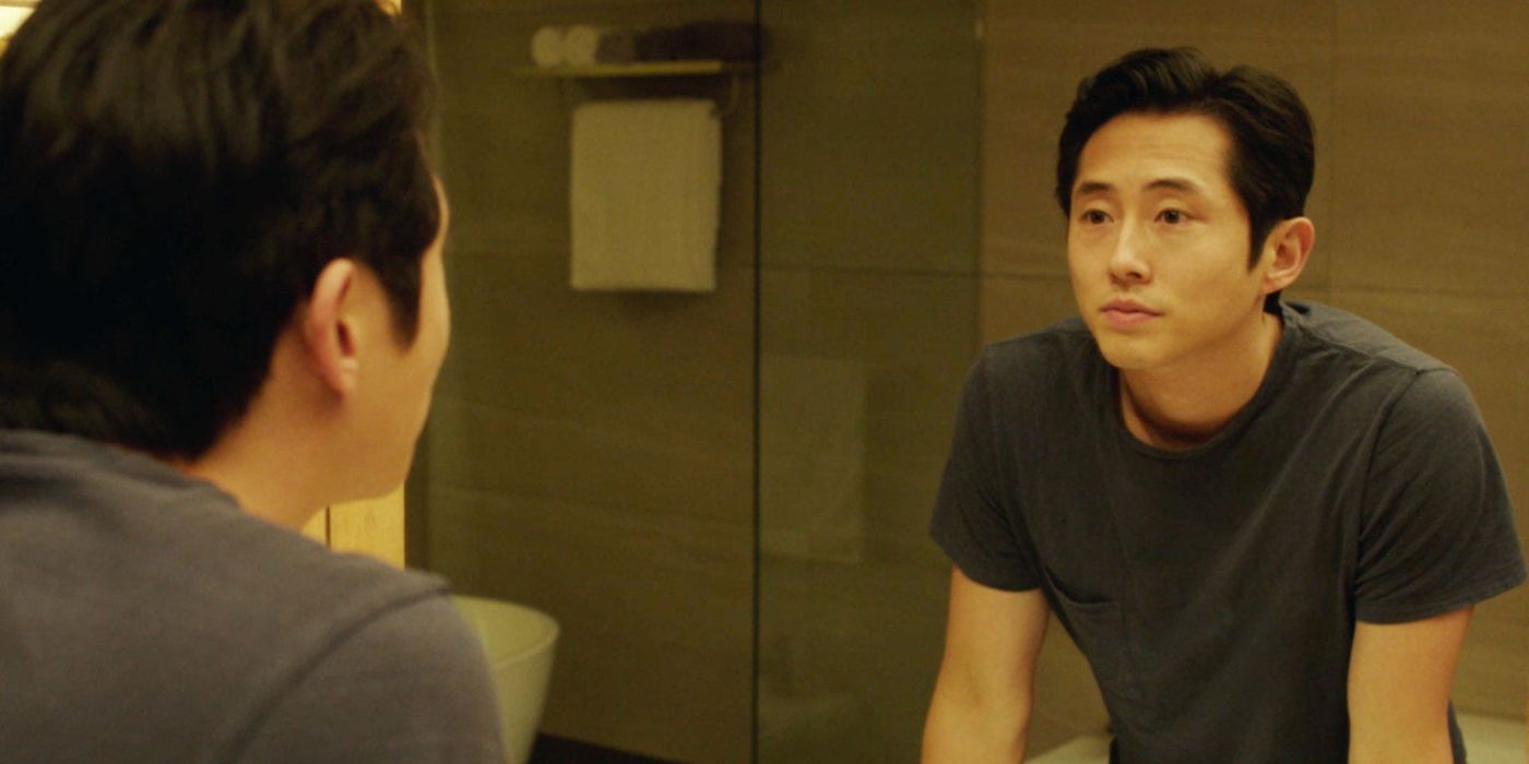 Steven Yeun looking at himself in the mirror in Burning