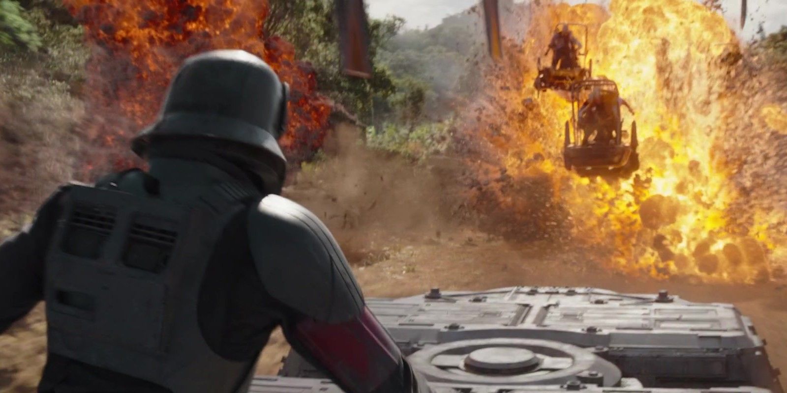 Din Djarin stands on top of a Juggernaut troop transport and watches as his pursuers are blown up in The Mandalorian Chapter 15: The Believer