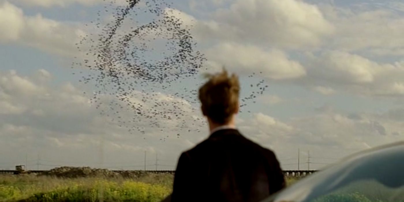 Matthew McConaughey's Rust Cohle from behind looking at a spiral patter in the sky in True Detective season 1