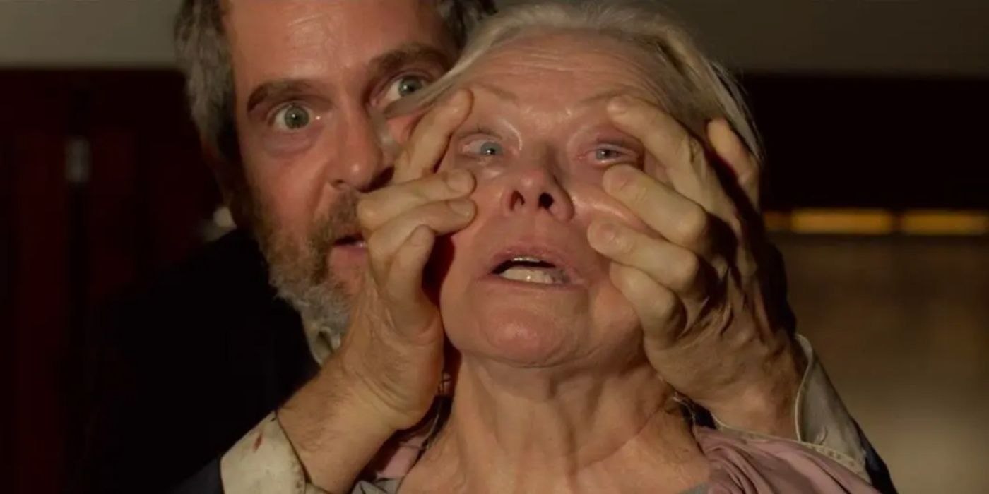 Tom Hollander como Gary mantendo abertos os olhos de uma mulher em Bird Box