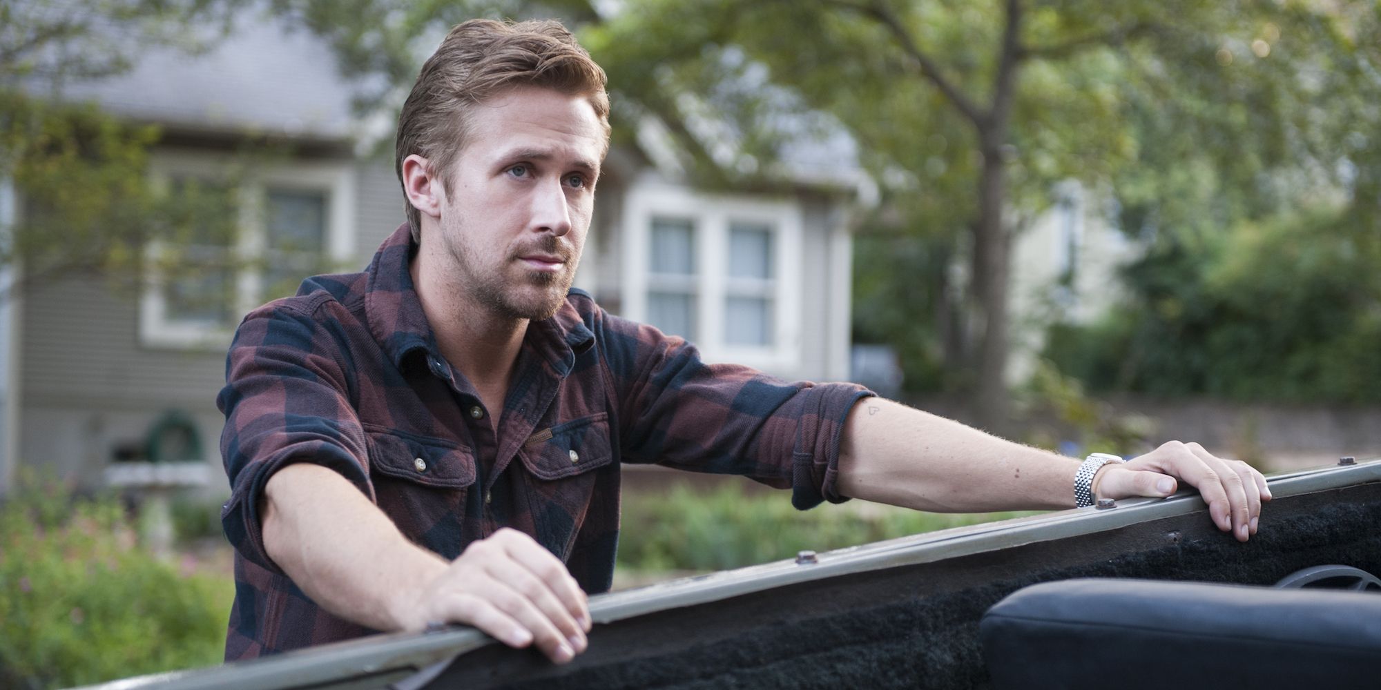BV (Ryan Gosling) gripping the edge of a vehicle in Song to Song.