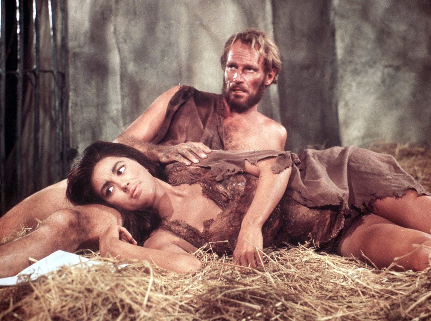 Still from 1968’s Planet of the Apes, featuring Nova laying her head on Taylor’s lap, atop a pile of hay