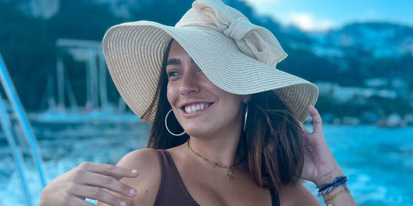 Priscila Ferrari from Vanderpump Villa smiling in hat by pool