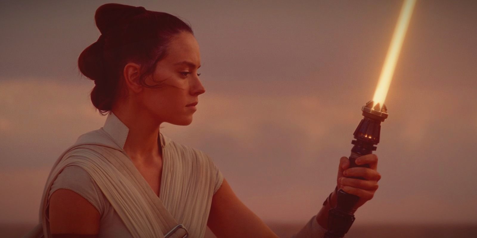 Rey Skywalker holding her yellow lightsaber in The Rise of Skywalker