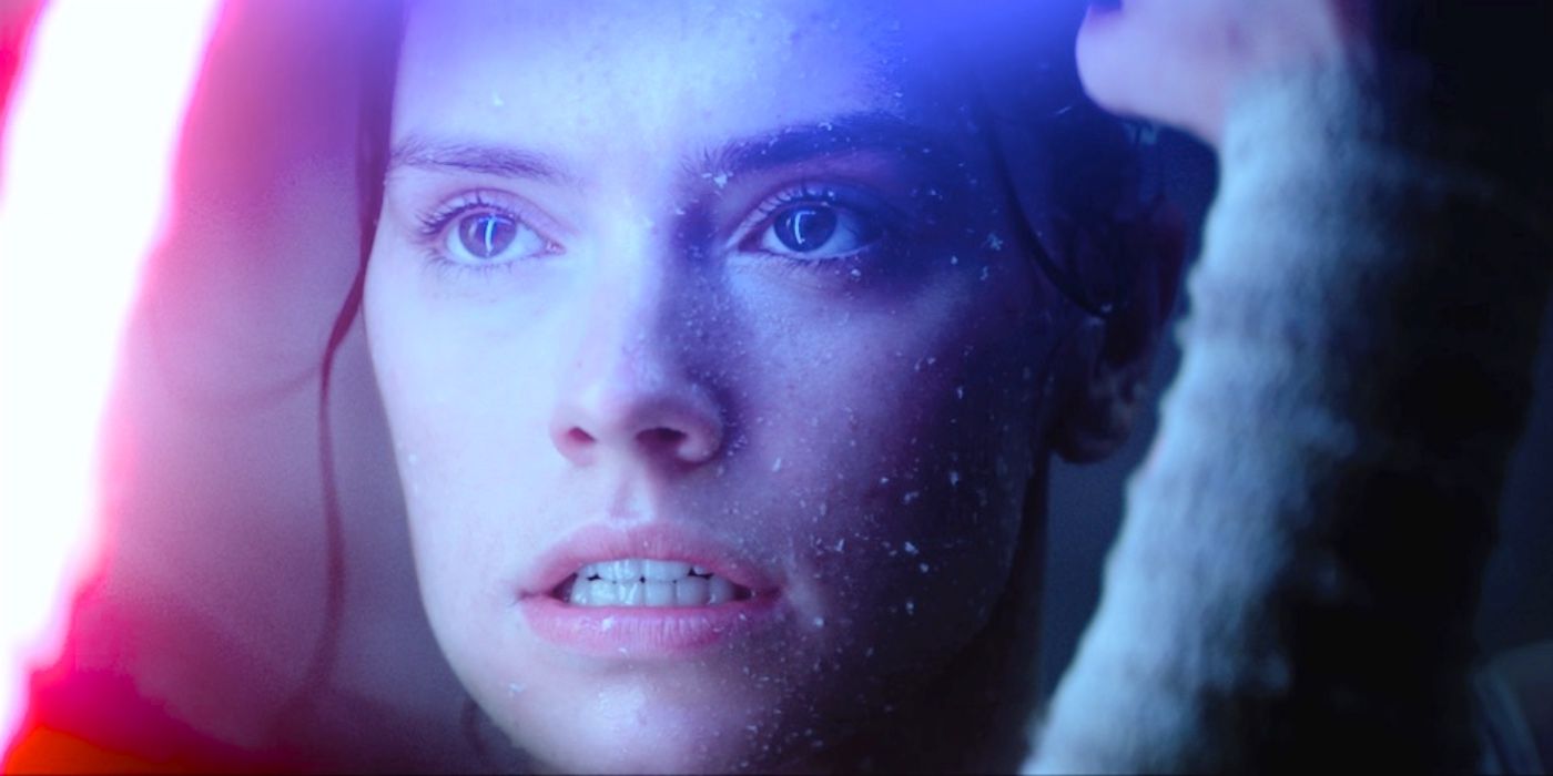 A close up of Rey with the glow of red and blue lightsabers from The Force Awakens