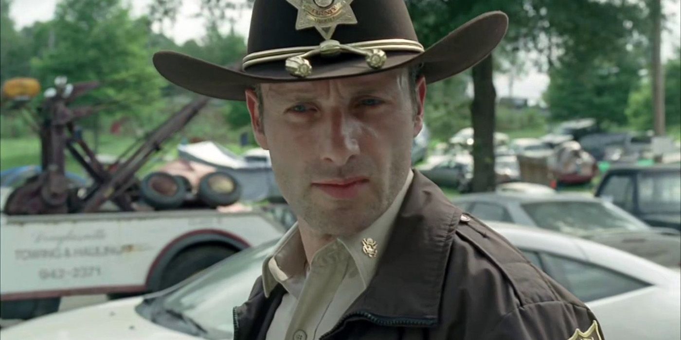 Rick Grimes standing among abandoned cars in The Walking Dead series pilot