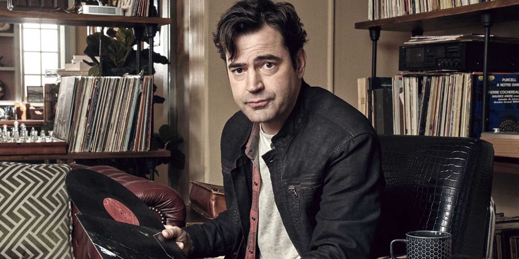 Ron Livingston's Loudermilk sitting holding a record in Loudermilk