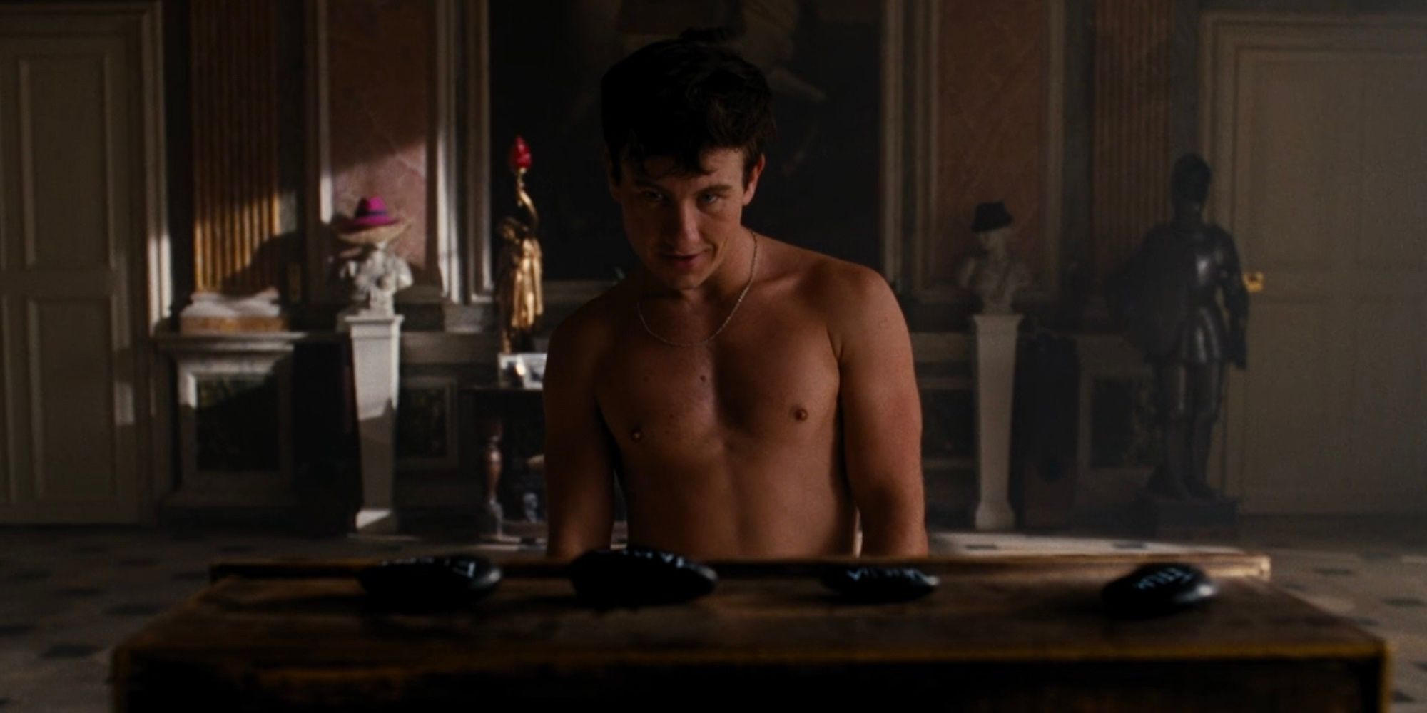 A shirtless Oliver (Barry Keoghan) looking at the Catton family's death stones at the end of Saltburn.