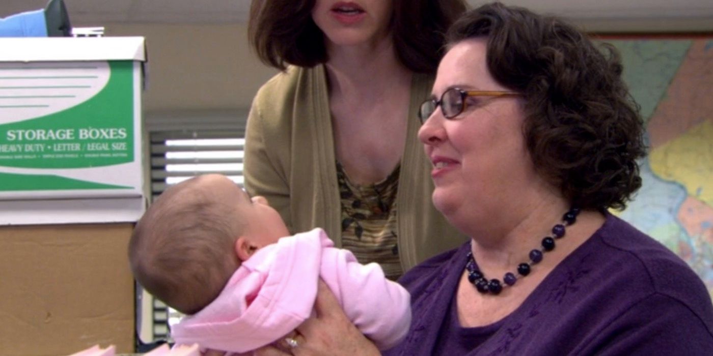 Phyllis segurando um bebê no escritório.