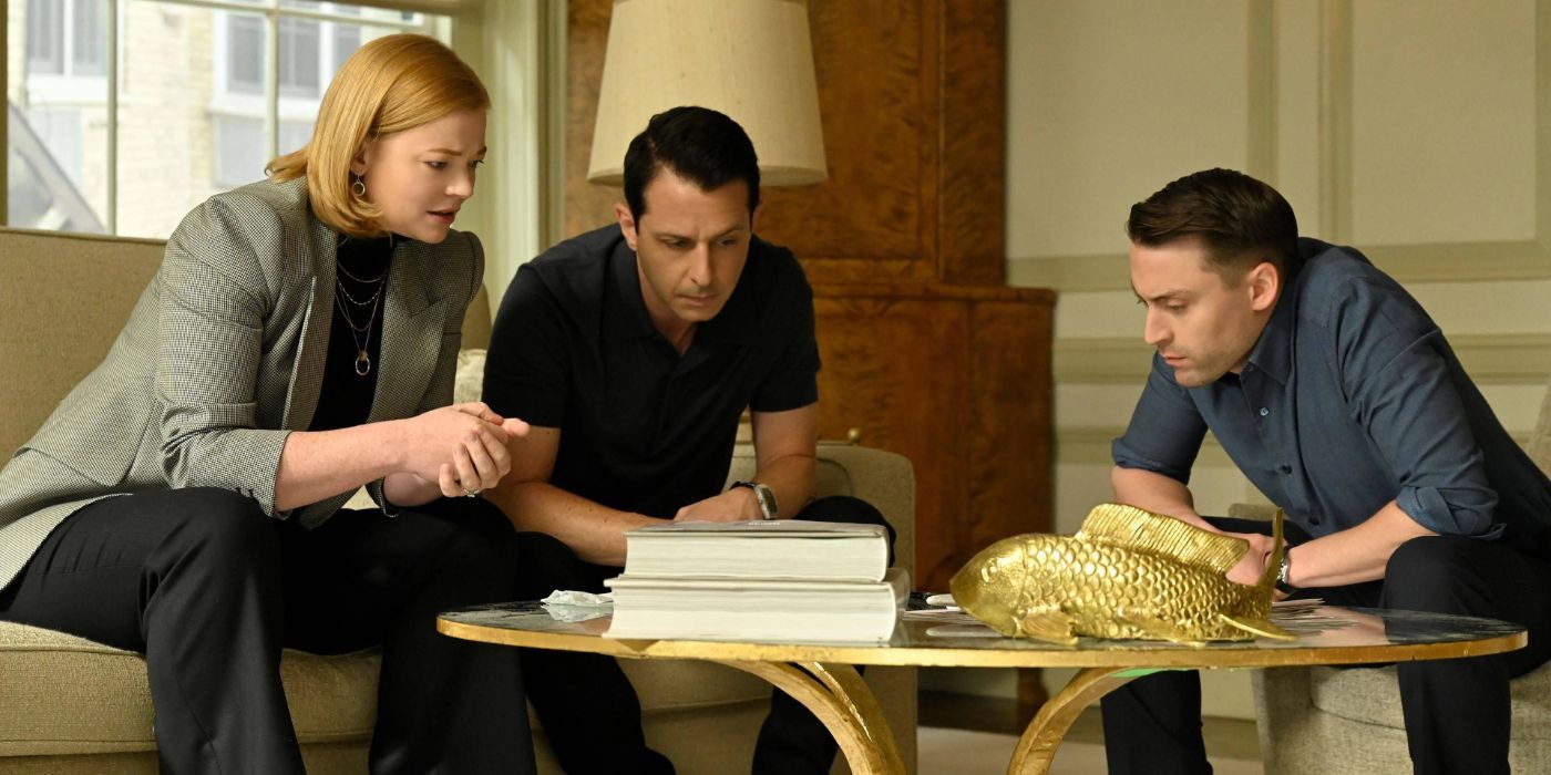 Shiv (Sarah Snook), Kendall (Jeremy Strong), and Roman (Kieran Culkin) leaning in and talking together on a phone in Succession season 4 episode 4 Honeymoon States.