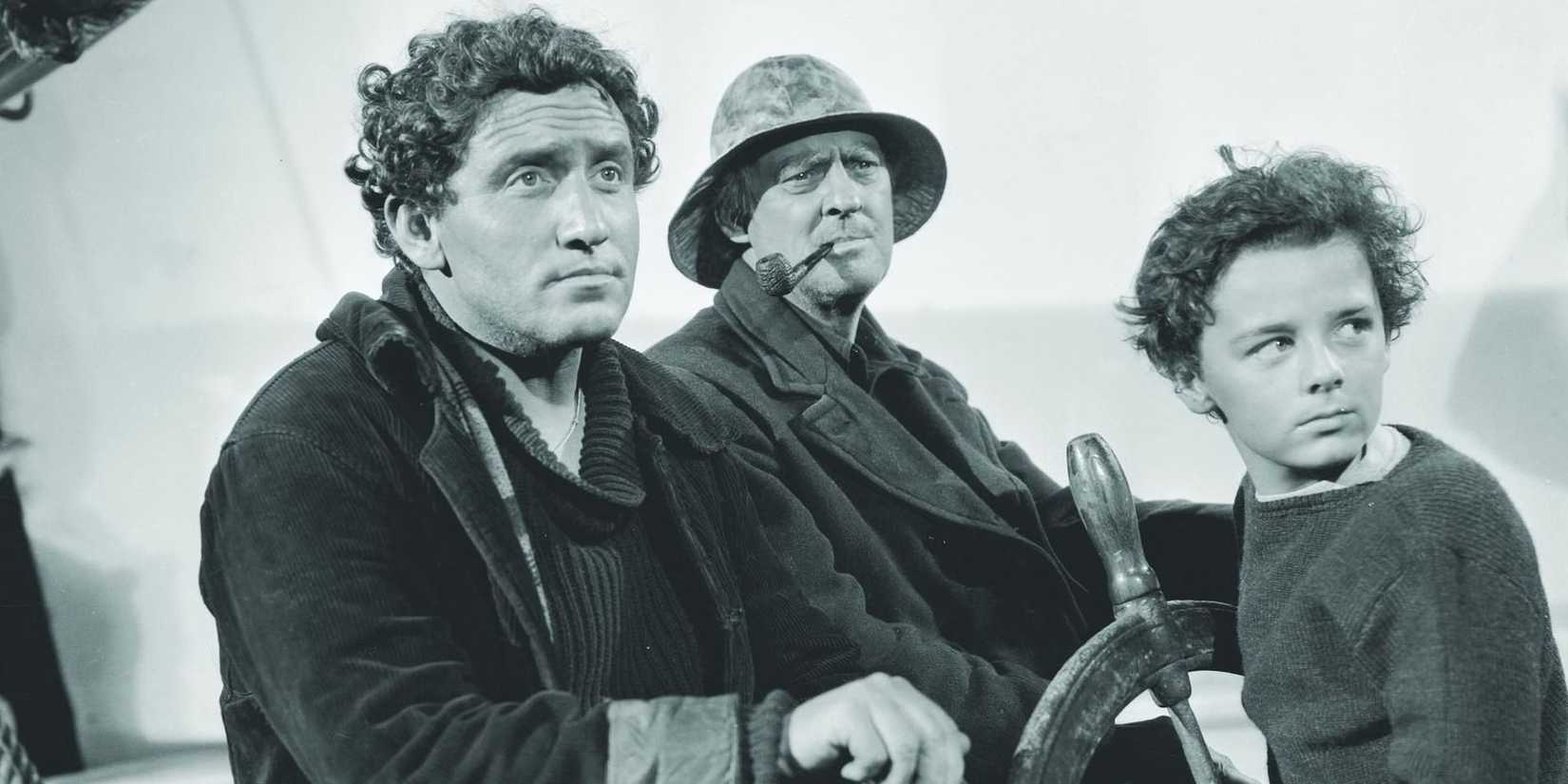 Manuel (Spencer Tracy) and Disko steering the boat with Harvey (Freddie Bartholomew) in Captains Courageous.