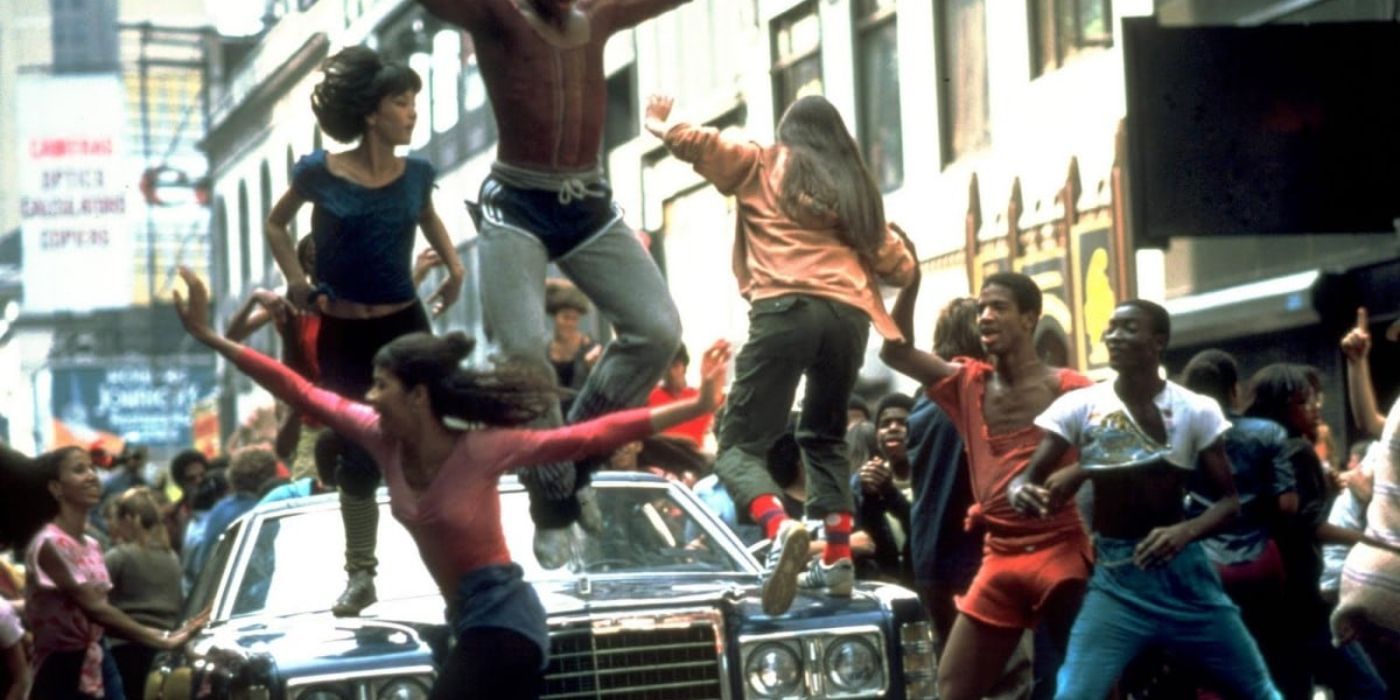 Students dancing on top of a car in the street in Fame.