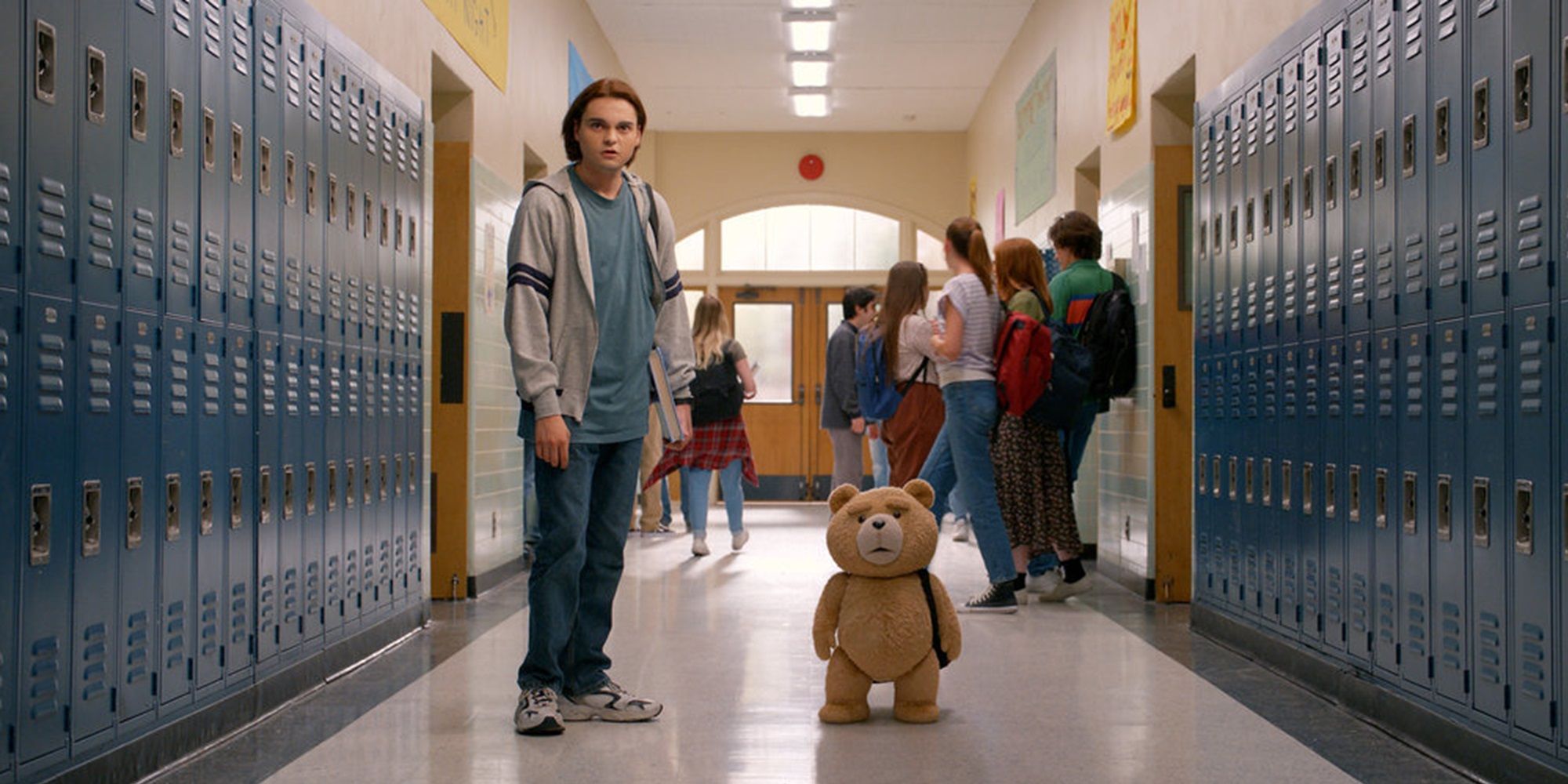 Ted e John no corredor de uma escola em Ted