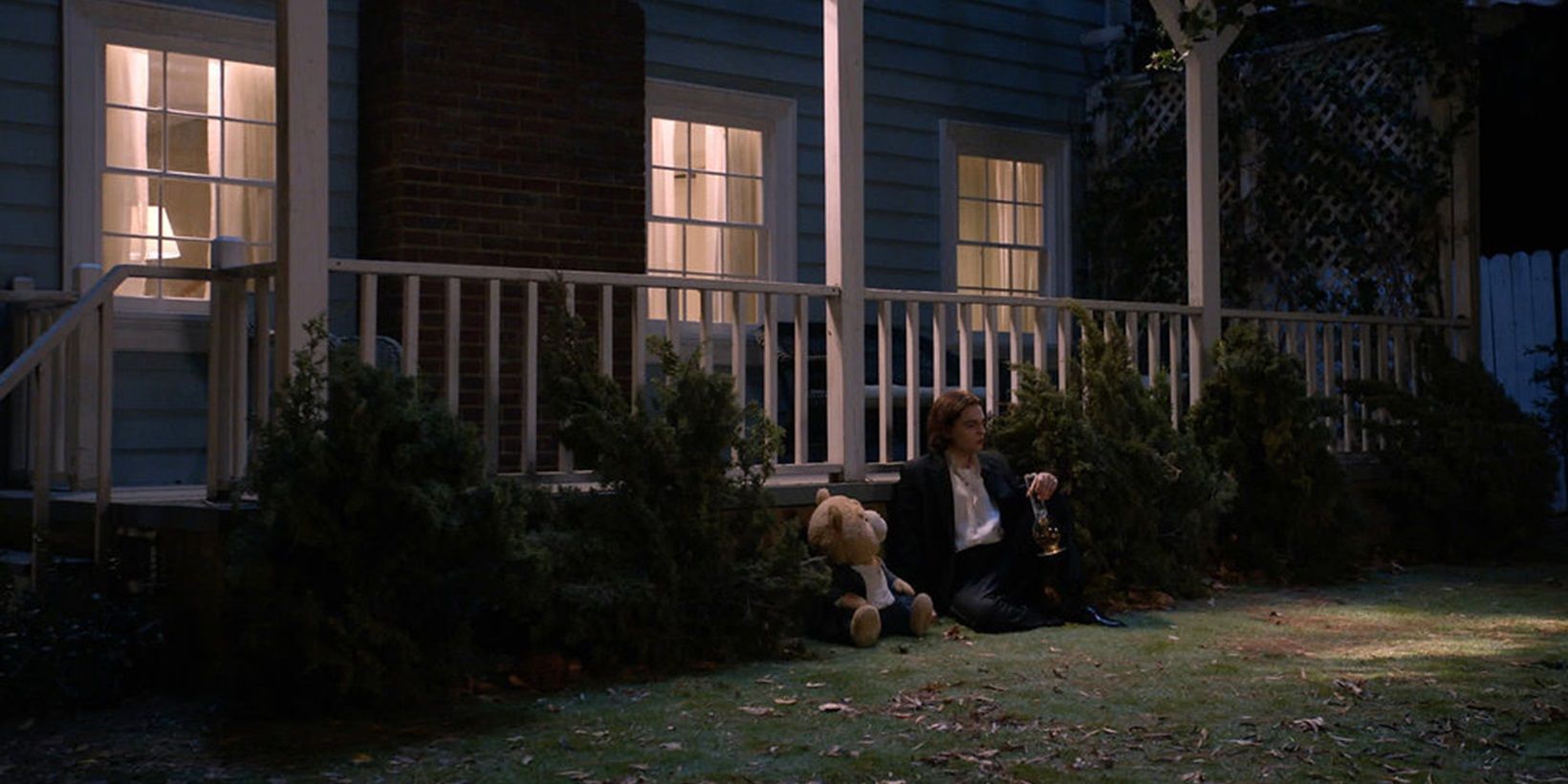 Ted and John sit on the lawn in Ted