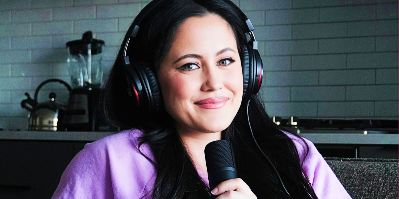 Teen Mom star Jenelle Evans smiles slightly while wearing headphones and holding microphone