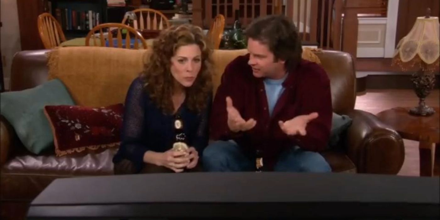 Nia and Thomas sat on a sofa together in My Big Fat Greek Life