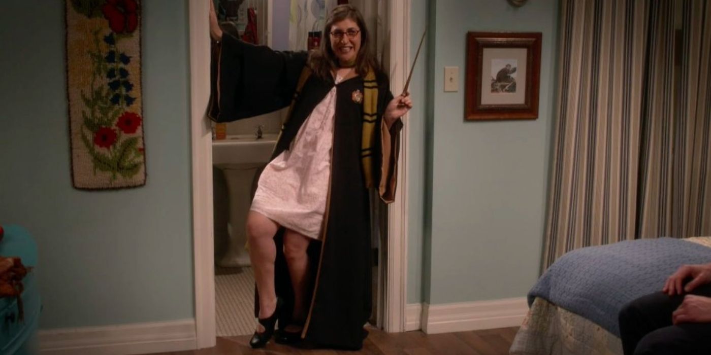 Amy posing against a doorway in a Gryffindor robe in The Big Bang Theory