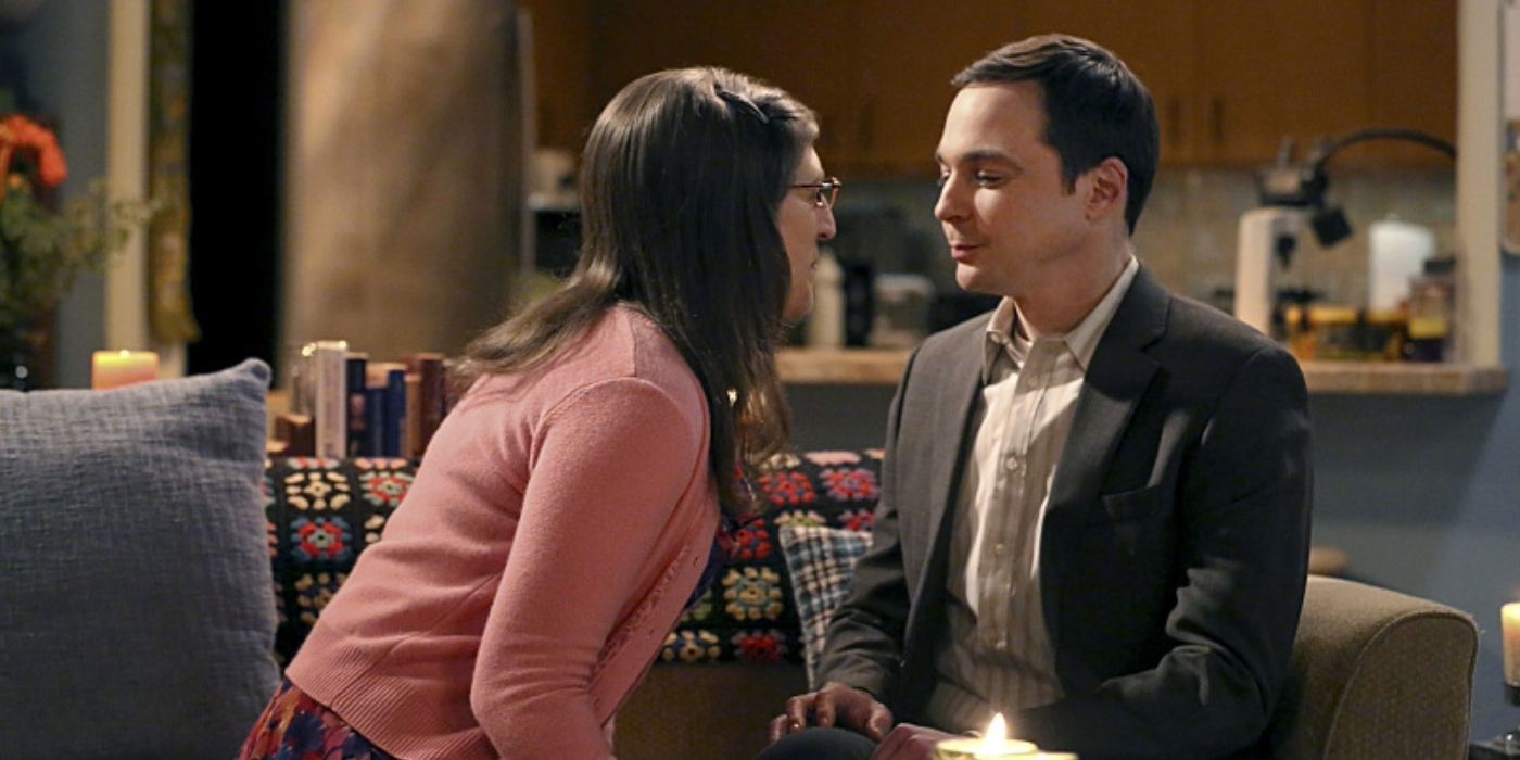 Amy and Sheldon about to kiss on her couch in The Big Bang Theory