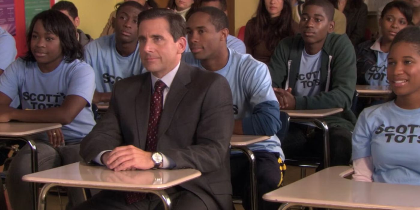 Michael (Steve Carrel) sitting in a high school surrounded by the Scott's Tots in The Office season 6